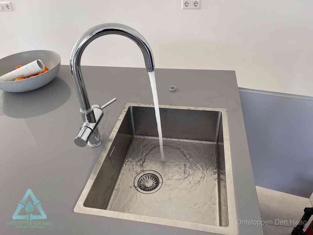 Een vrij doorstromende rvs spoelbak waar het water moeiteloos wegloopt, het resultaat van slim onderhoud dat geld bespaart in Den Haag