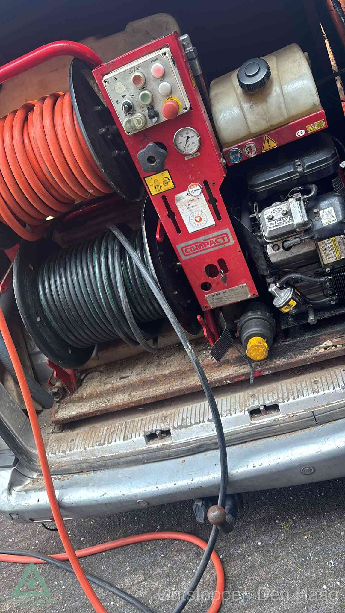 Een rood hogedruk-rioolreinigingstoestel in de laadbak van de bedrijfsbus, apparatuur voor een hardnekkige afvoerverstopping in Den Haag