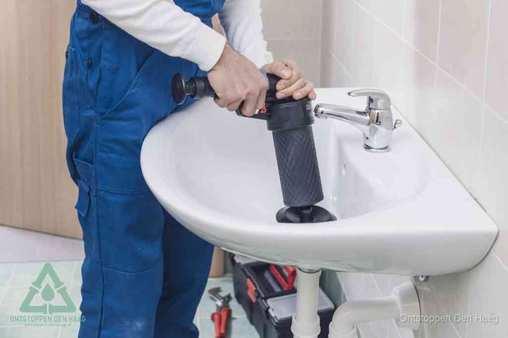 Een te ruwe doe-het-zelf poging met een hand-pomp op de afvoer van een badkamer-wastafel, een van de veelgemaakte fouten bij afvoer ontstoppen in Den Haag