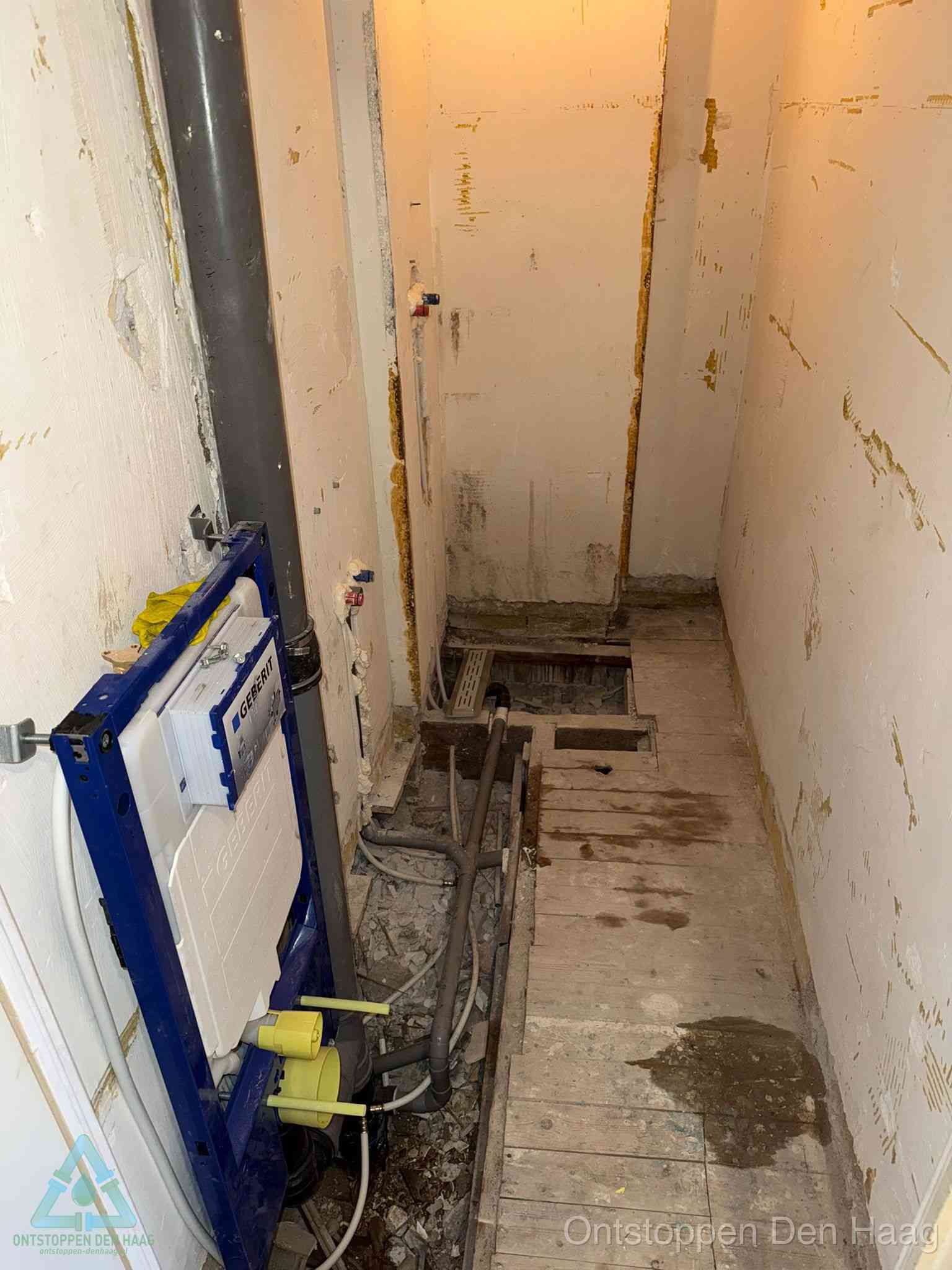 Een opgebroken toiletruimte tijdens renovatie met een Geberit inbouwreservoir en blootliggende oude afvoerleidingen, typisch voor oudere woningen in Den Haag